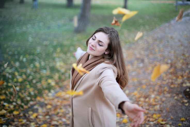 woman open arms while closed eyes smiling photo